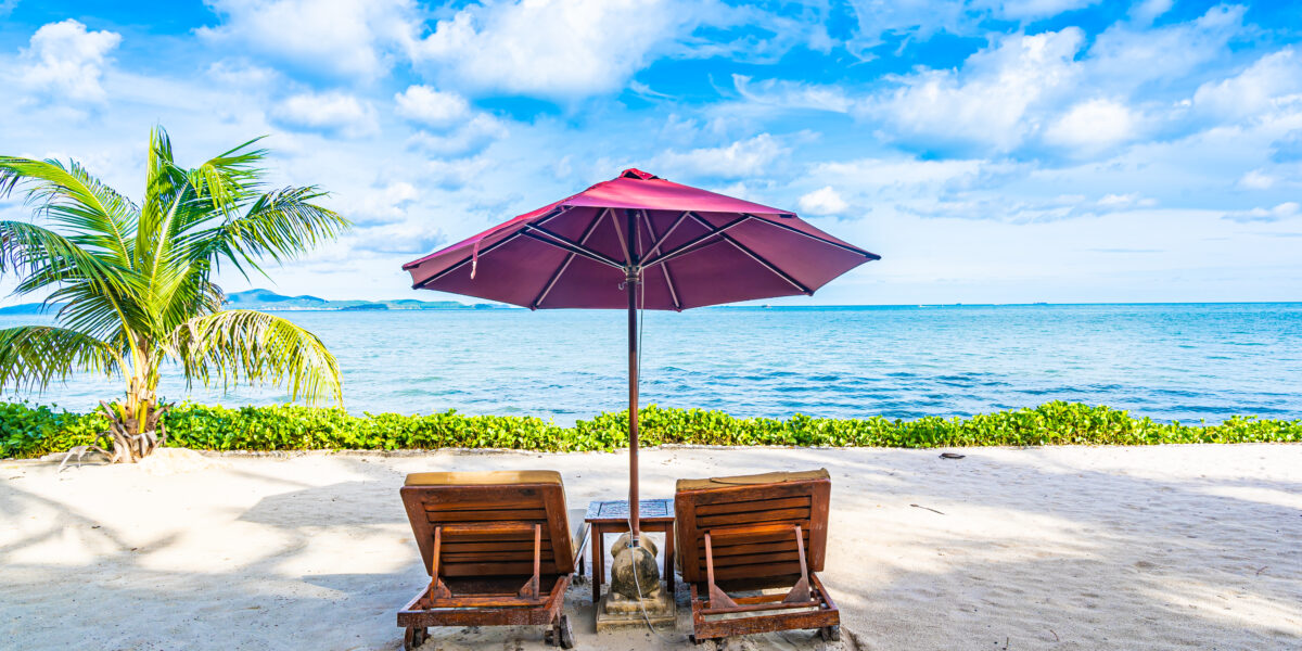 Beautiful landscape of beach sea ocean with empty chair deck and umbrella nearly coconut palm tree with white cloud and blue sky for leisure travel in holiday vacation